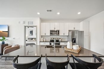 A kitchen and dining room with a table and chairs